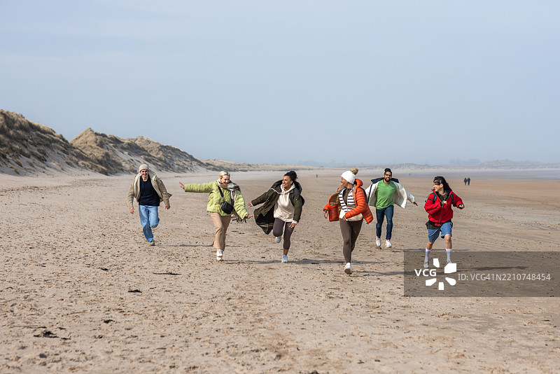 无忧无虑的朋友们在沙滩上玩得很开心图片素材