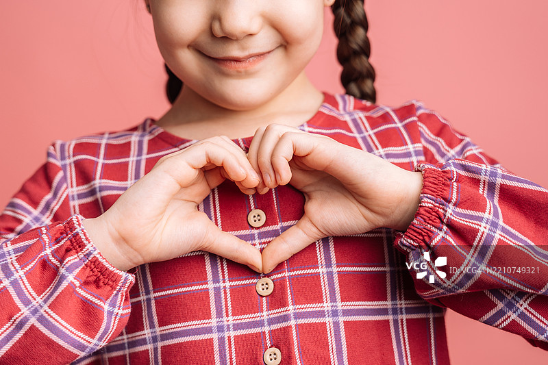 小女孩用手做出心形，母亲节图片素材
