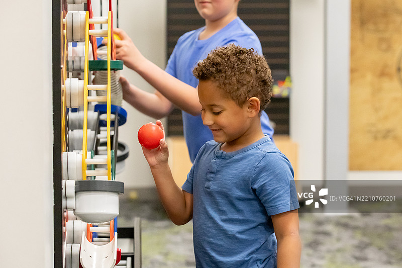 可爱的小男孩在现代科学教室里使用教育性STEM玩具图片素材