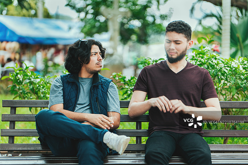 在尼加拉瓜埃斯特利，男人在公共场合吸烟，向身边的人吐烟。图片素材