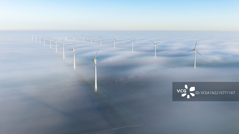 宁静的风力发电机场景，四周被浓雾笼罩图片素材