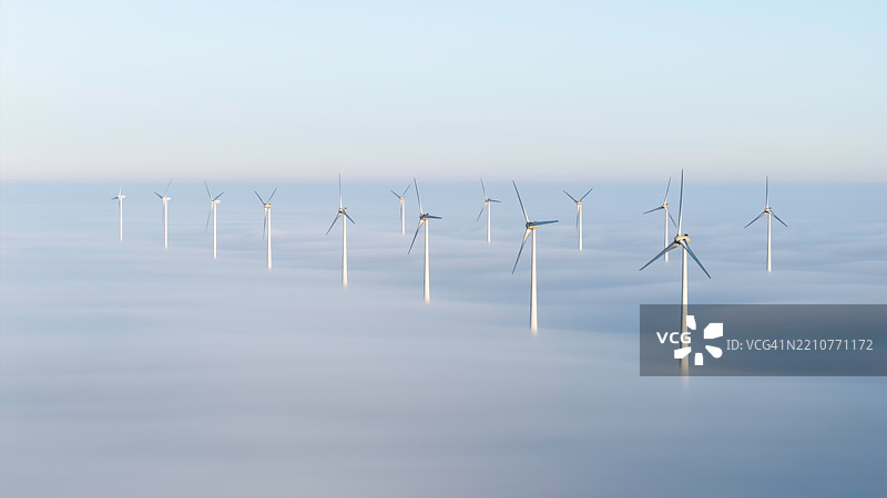 被雾气环绕的风力涡轮机宁静场景图片素材
