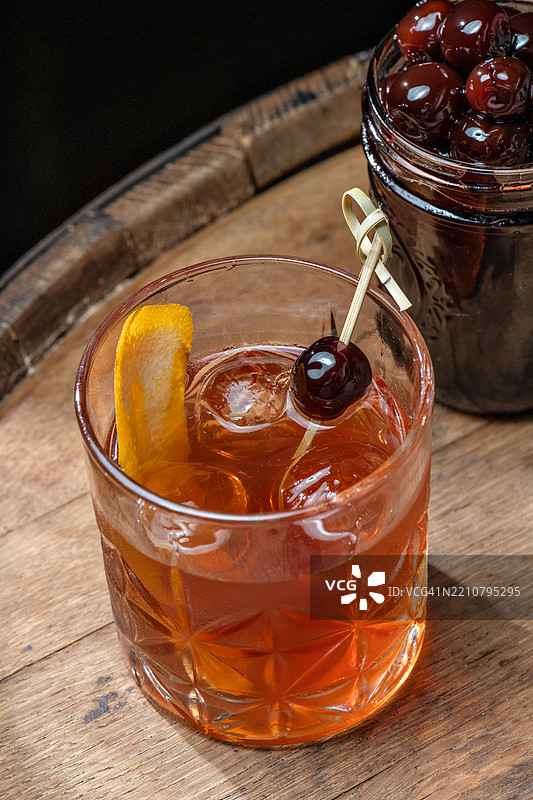 波本威士忌鸡尾酒，配圆形冰块和樱桃图片素材