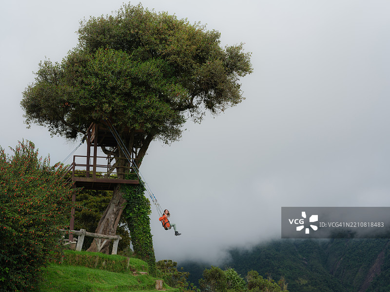 厄瓜多尔巴尼奥斯雨林中的秋千上的女人图片素材