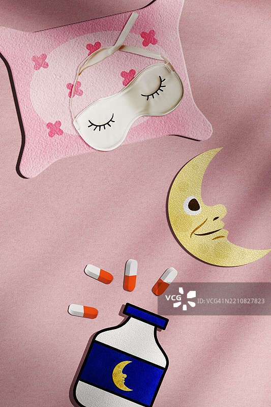 粉色背景上，枕头旁的眼罩和耳塞，帮助克服失眠的俯视图图片素材