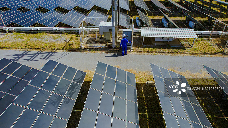 服务工程师检查太阳能发电厂的鸟瞰图。图片素材