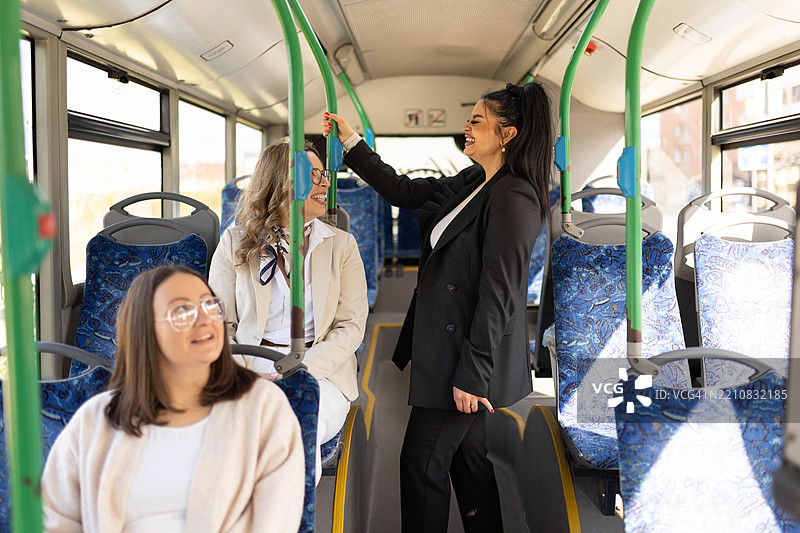 女人们在城市公交车上交谈和骑行。图片素材