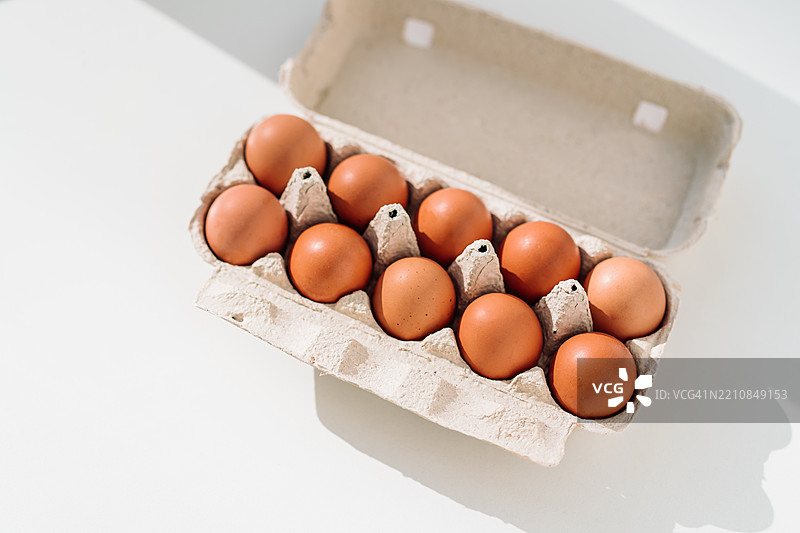 白色背景上纸 carton 中的新鲜棕色鸡蛋俯视图图片素材
