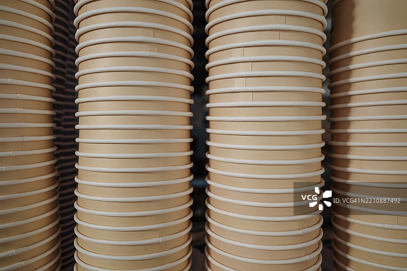 高高的米色一次性纸杯堆。图片素材