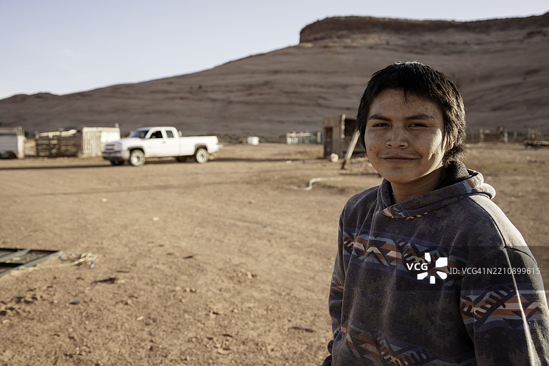 环境肖像：十五岁的纳瓦霍男孩在亚利桑那州纪念谷的沙漠地区图片素材