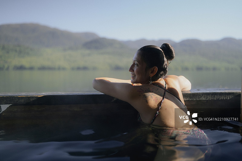 游客在温泉中放松，享受山景图片素材