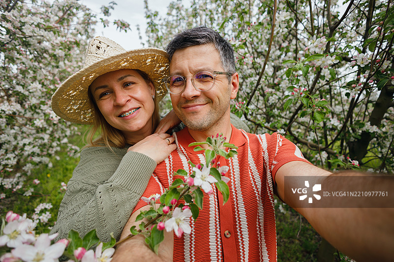 在苹果园中拍自拍的情侣图片素材