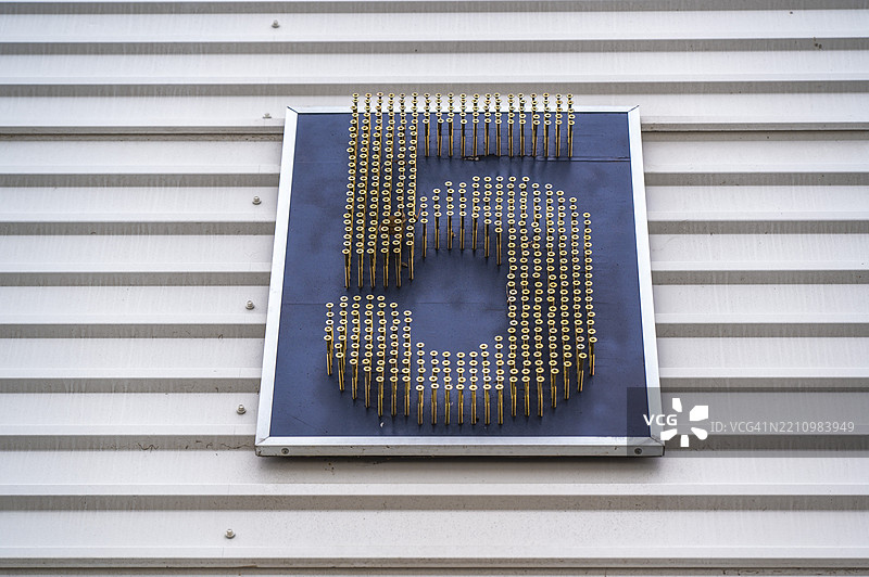 五个金属螺栓展示在纹理墙上，激发城市环境中的创意设计灵感图片素材