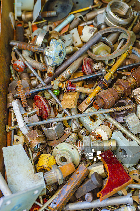 各种金属紧固件和零件收集在一个装满硬件的复古工具箱中，位于一个工作坊里图片素材