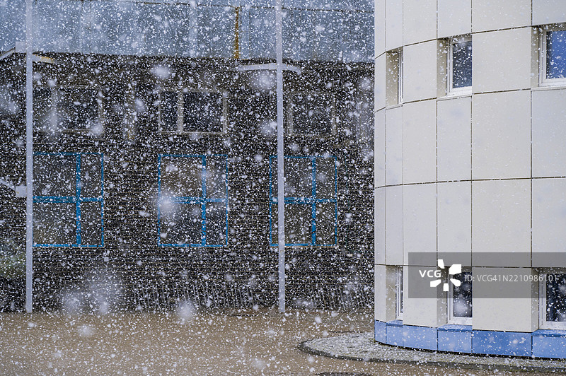 雪花在现代建筑和城市环境附近营造出宁静的氛围图片素材
