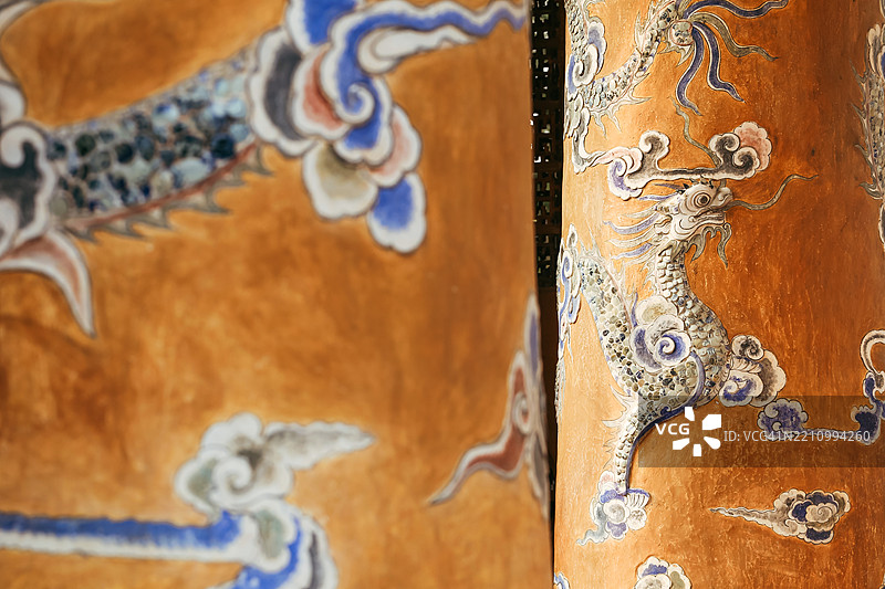 越南中部黄色墙柱上的蓝色龙雕刻图片素材