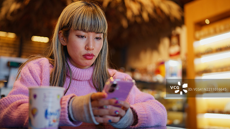 女性在咖啡馆使用手机图片素材