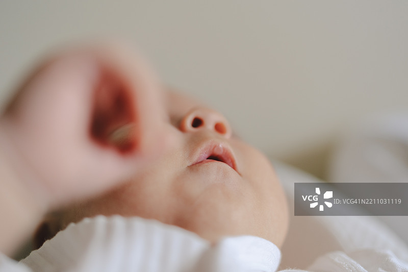 新生儿面部特写，柔和聚焦于嘴唇和脸颊。图片素材