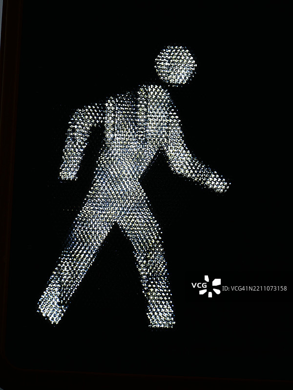 在黑色背景下的背光行人：曼哈顿，纽约州，美国的行人过街信号特写。图片素材