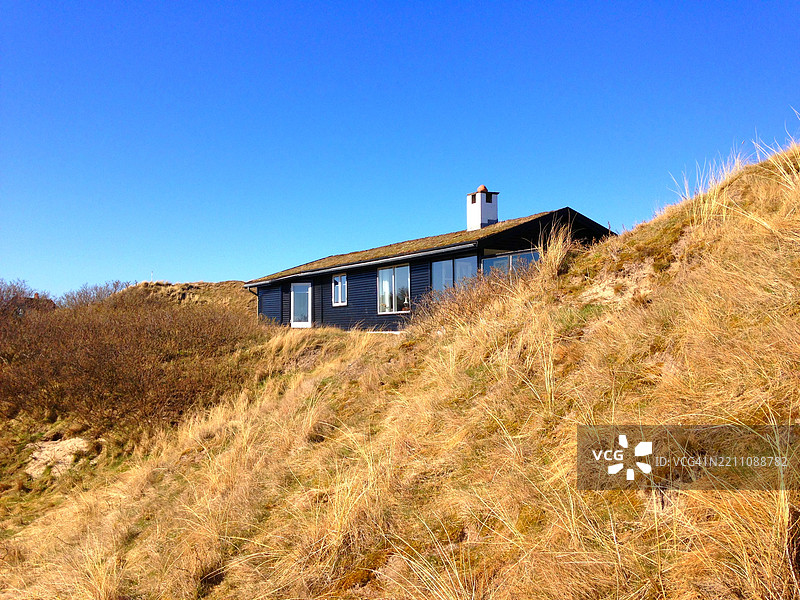丹麦尤兰半岛法诺岛的沙丘中，传统木制夏屋与草屋顶图片素材