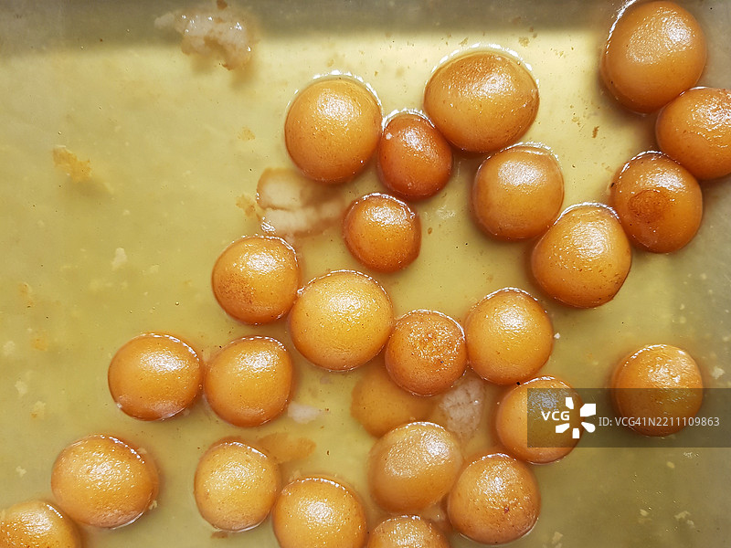 受欢迎的印度和巴基斯坦甜点古拉布贾蒙（甜球），浸泡在糖浆中，准备好食用和上桌。图片素材