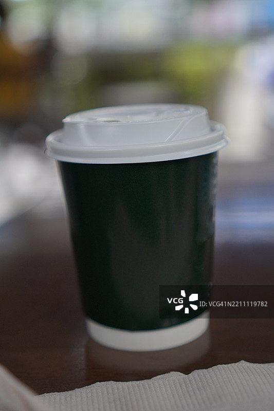 木桌上的纸杯热咖啡图片素材