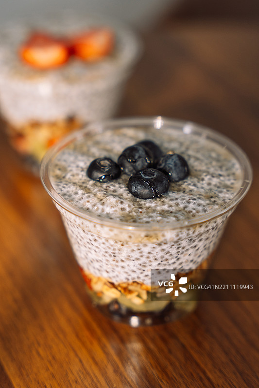 蓝莓和燕麦片的奇亚籽布丁装在塑料外卖杯中图片素材