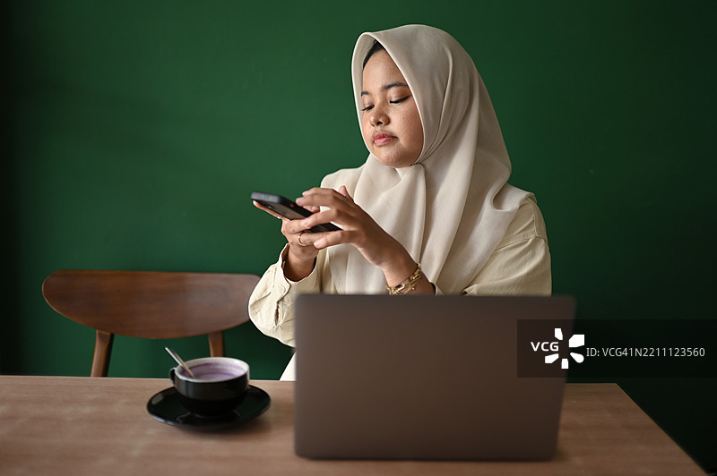 亚洲女性用智能手机拍摄咖啡馆的照片图片素材