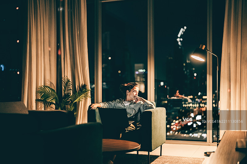 一位孤独的女性在大城市的豪华公寓中感到忧郁图片素材