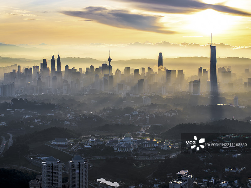 金色的晨光透过马来西亚吉隆坡的天际线,照亮了如双子塔、吉隆坡塔、交易所106和独立118等重要地标。图片素材