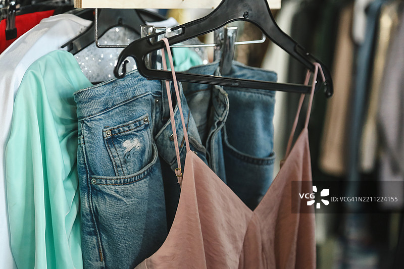 灰粉色优雅丝绸背心与牛仔裤和街头跳蚤市场的二手衣物相映成趣图片素材