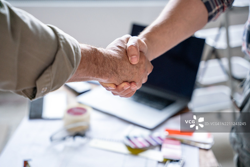 两位专业人士在建筑工地握手达成协议图片素材