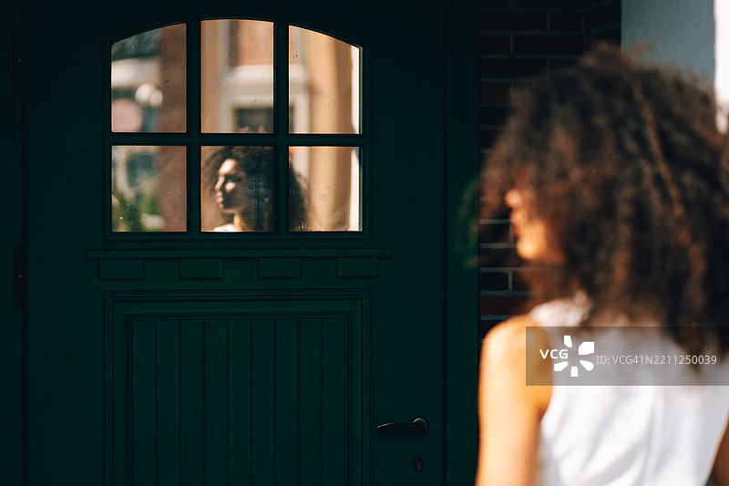 神秘的倒影。年轻女性在门镜中的倒影图片素材