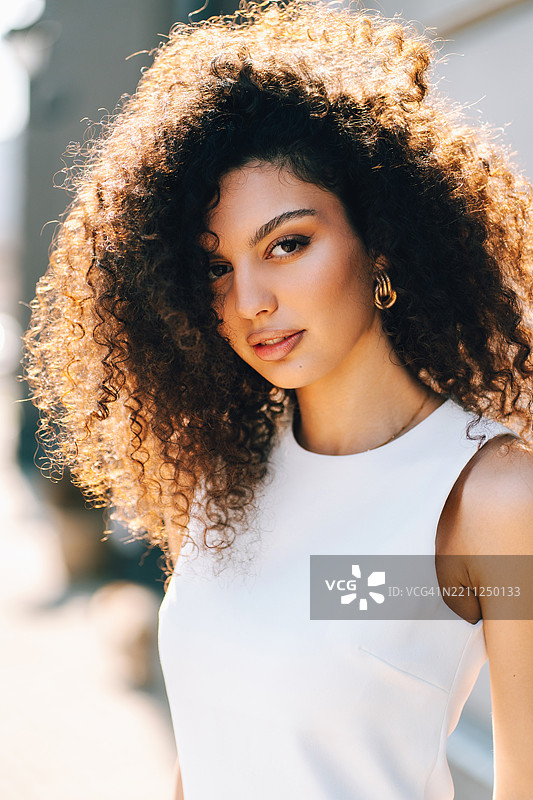 年轻女性以非洲卷发造型摆姿势并注视镜头图片素材
