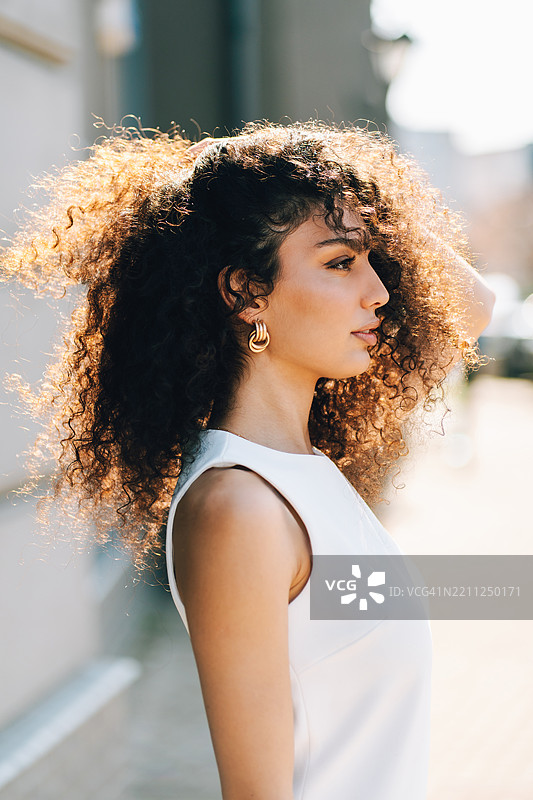 迷人的多种族女性侧面肖像，卷发飘逸图片素材
