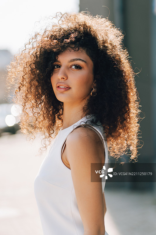 自然美的女性。拥有卷发的跨种族女性在户外摆姿势。图片素材