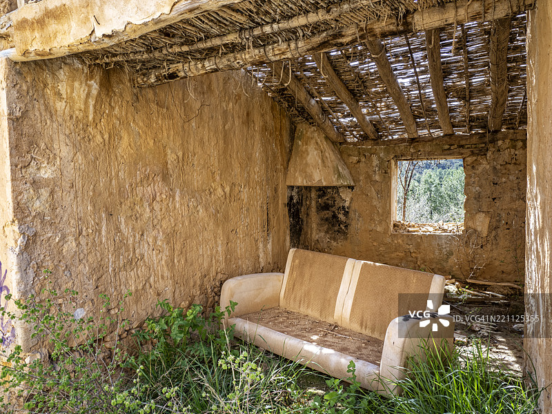 一把扶手椅位于因农村人口减少而废弃的破旧房屋内。图片素材