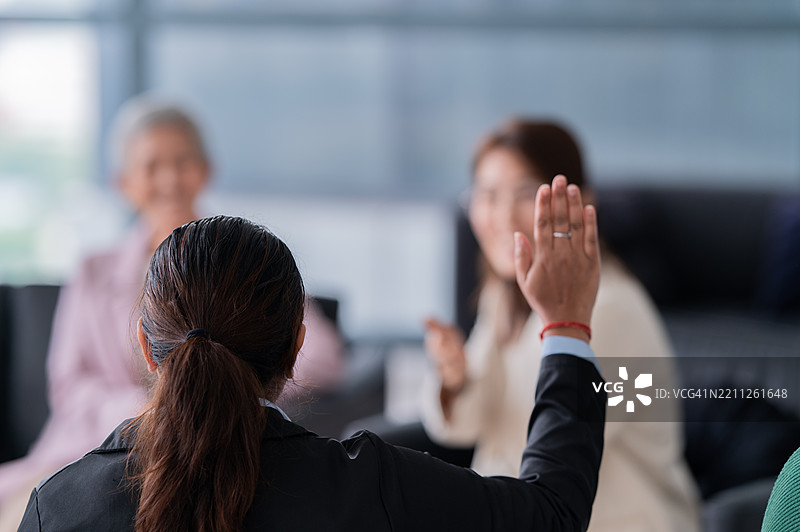 室内亚洲商业会议，一位印度女性举手提问图片素材
