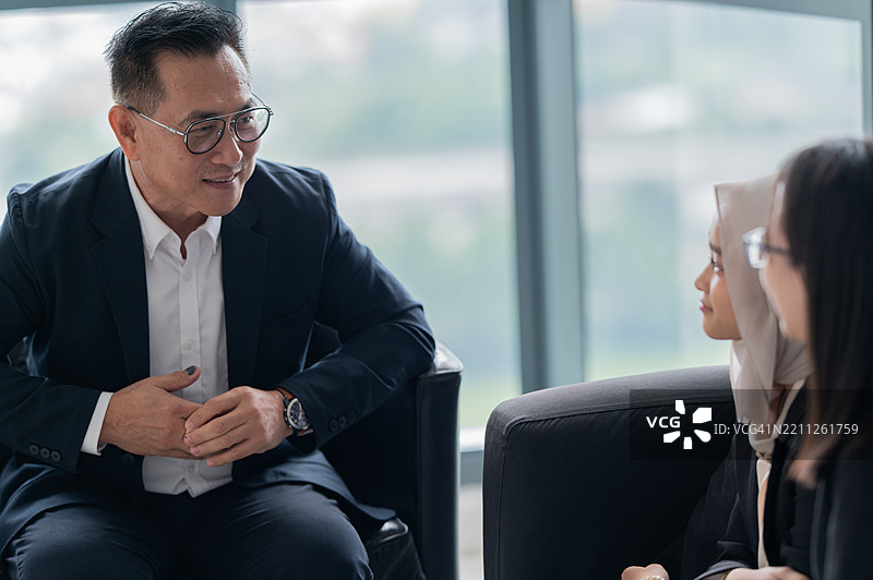 亚洲成功商人分享他的知识，并帮助年轻人实现成功图片素材