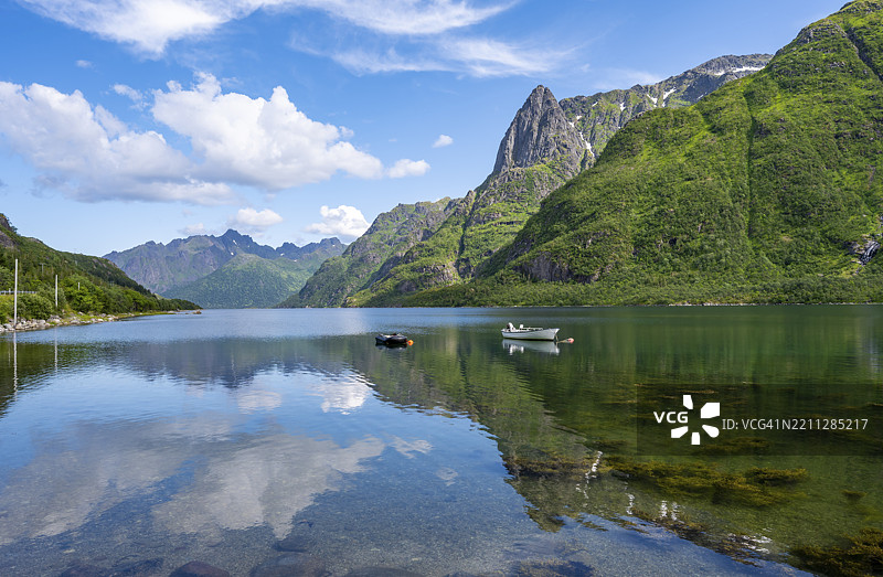 奥斯特内斯峡湾的小船，田园诗般的挪威峡湾风景，山脉倒映在水中，西尔德波伦，诺尔兰，挪威，欧洲图片素材