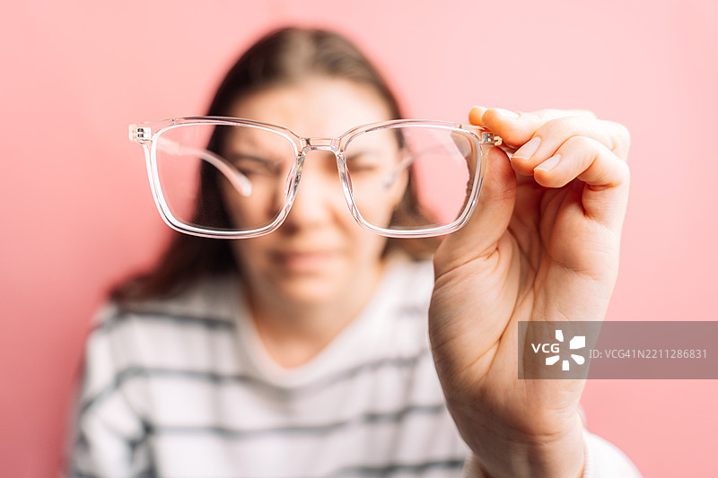 女士视力不佳，试图通过眼镜改善视力，近视。图片素材