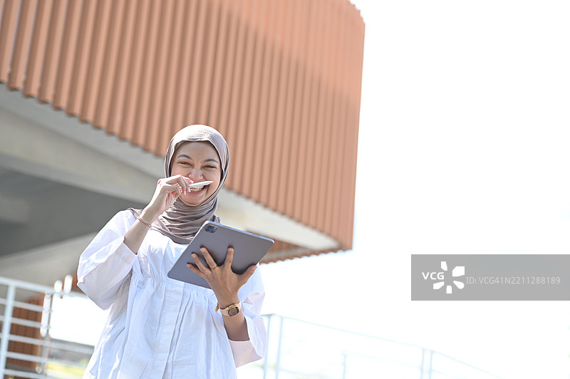 亚洲女性使用平板电脑绘制周围环境图片素材