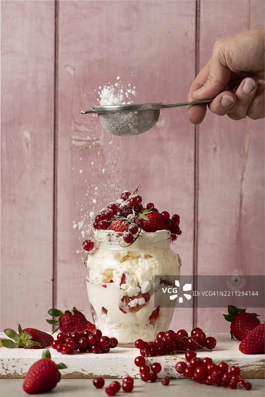 草莓和蔓越莓配奶油和蛋白霜的玻璃杯图片素材