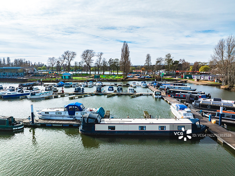 无人机拍摄的航拍照片，展示了一排停靠在码头的运河船。图片素材