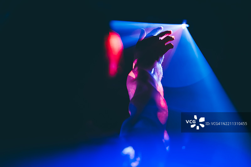 女人在霓虹灯背景下握着手。图片素材