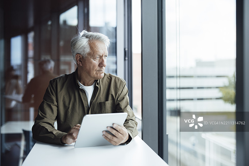 在现代办公室中使用平板电脑的高级建筑师图片素材