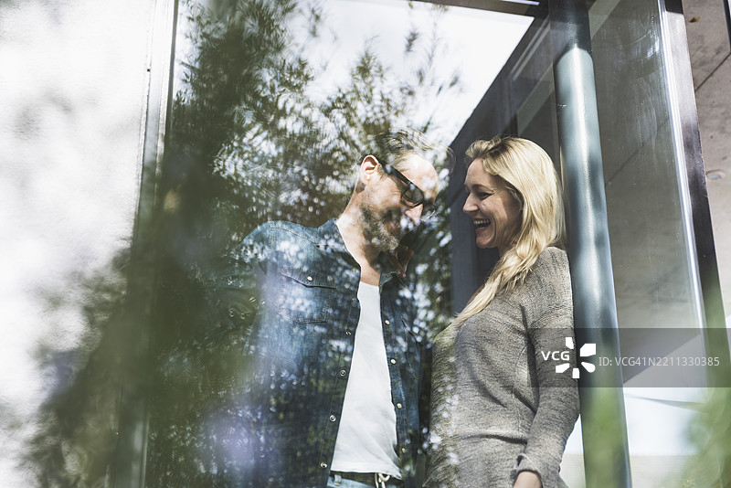 快乐的情侣在窗边享受共度时光图片素材