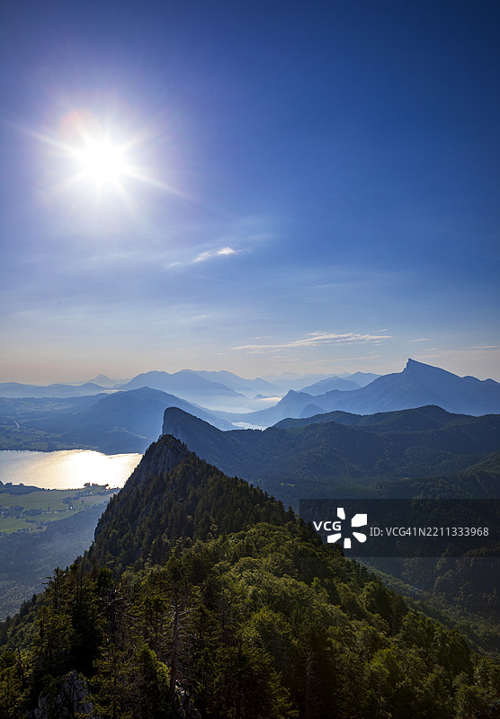 从施科伯山俯瞰奥地利萨尔茨卡默古特的蒙德湖，山脉轮廓与阳光交相辉映图片素材