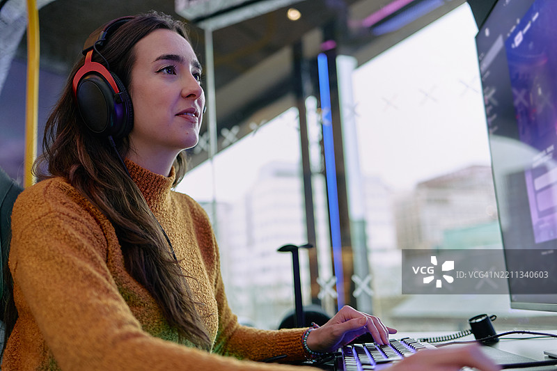 戴着耳机的玩家在游戏室里玩电脑游戏图片素材