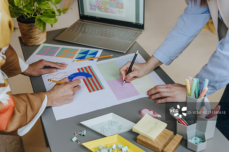 设计师们在现代桌子上合作进行图形设计项目图片素材